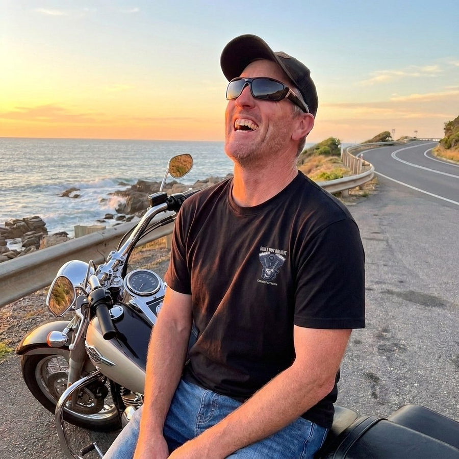 RIP MOTO crew rider in the Built Not Bought tee on a coastal road