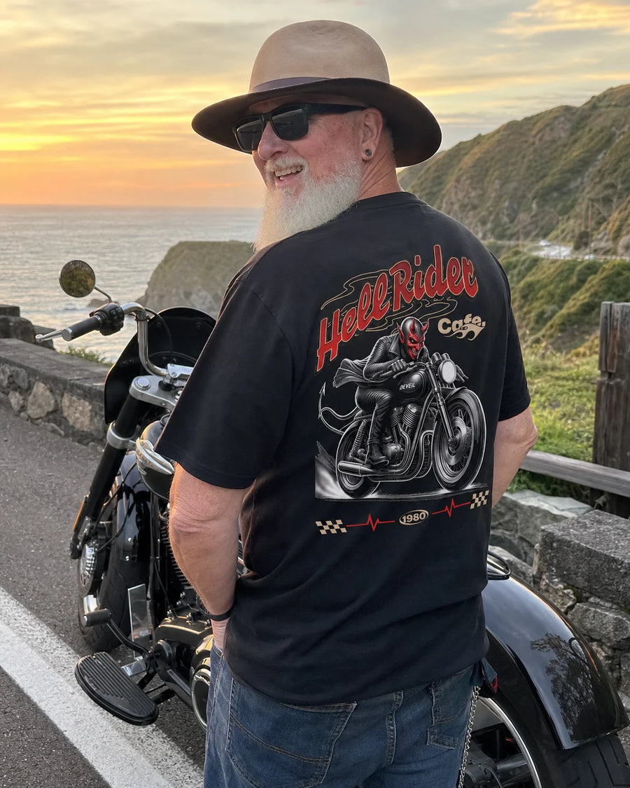 Rider wearing the RIP MOTO Hell Rider T-Shirt beside a motorcycle at sunset