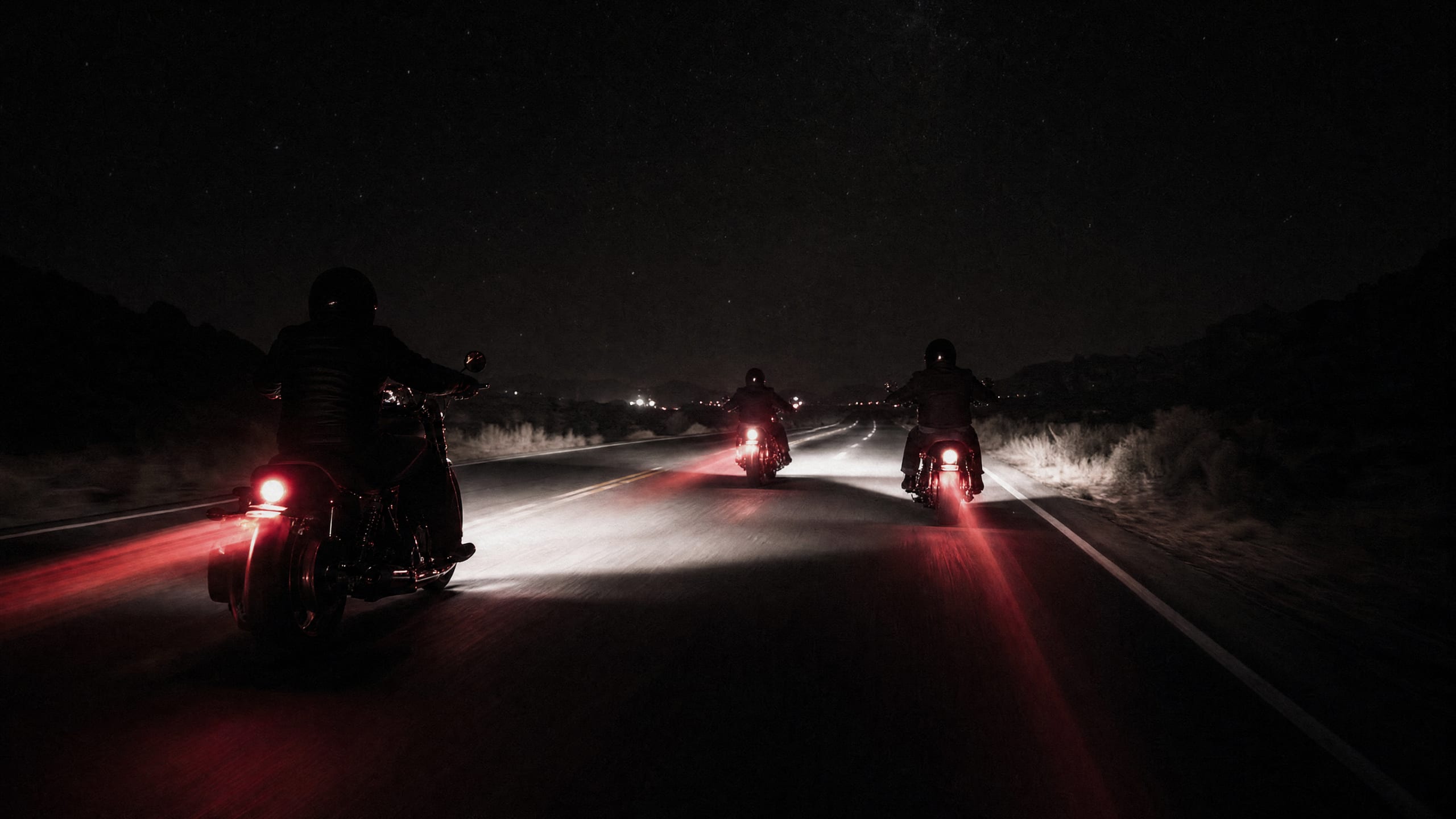 Cruisers riding into the night with red taillight streaks